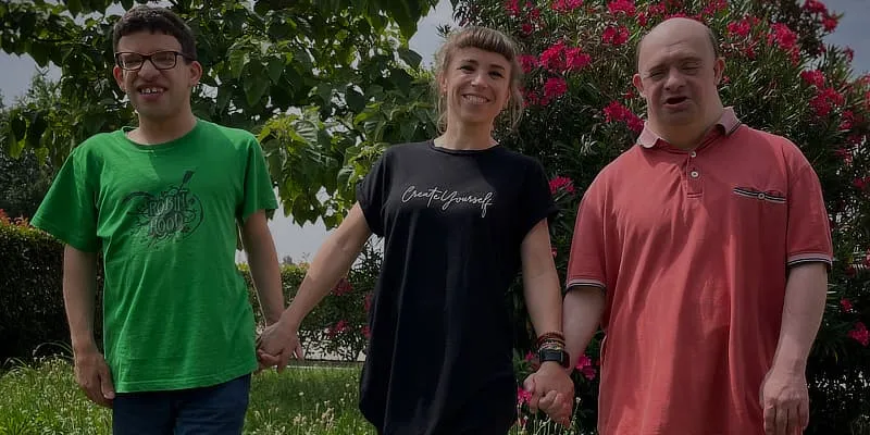 Foto con tre persone che si tengono la mano