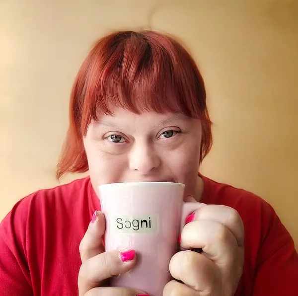 Monica che tiene in mano una tazza con la scritta sogni
